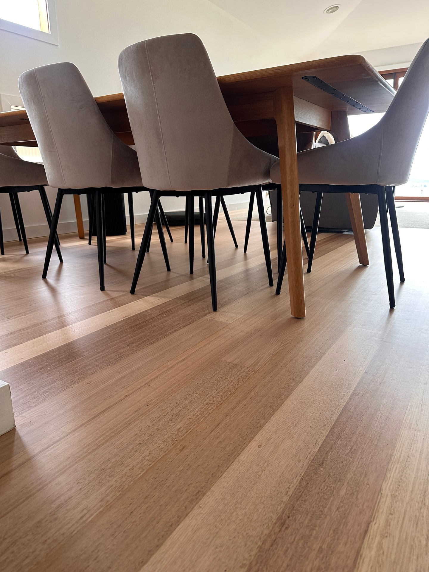 A lived-in dining room with the restored timber floor visible beneath the table and chairs